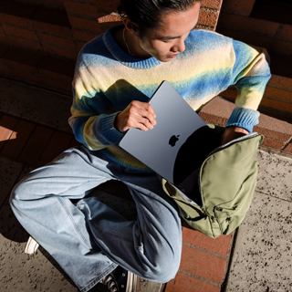 Imagen frontal de una persona guardando una MacBook Air de 15 pulgadas cerrada en una mochila