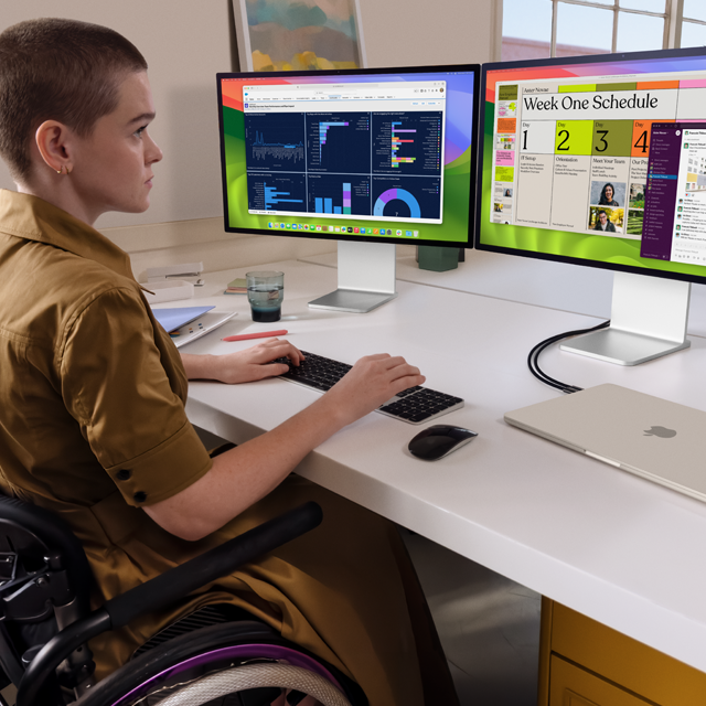 Una persona trabajando con dos monitores externos conectados a una MacBook Air de 15 pulgadas blanco estelar cerrada