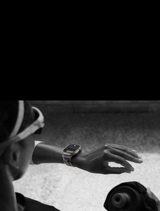 Una corredora mira su Apple Watch Ultra 2 en su muñeca izquierda mientras hace el gesto de doble toque con el dedo índice y el pulgar de la mano izquierda