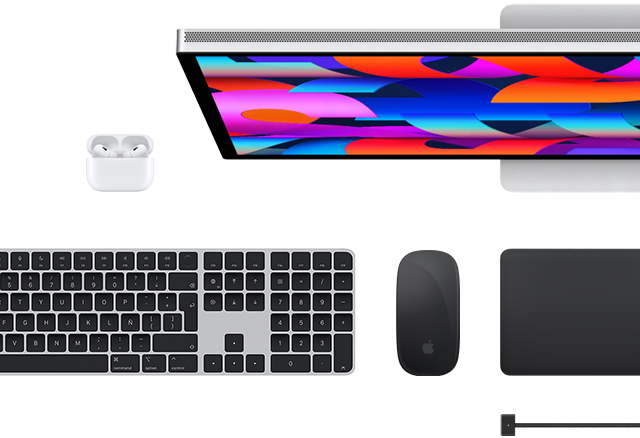 Vista desde arriba de algunos accesorios para la Mac: Studio Display, Magic Keyboard, Magic Mouse, Magic Trackpad, AirPods y cable de carga MagSafe