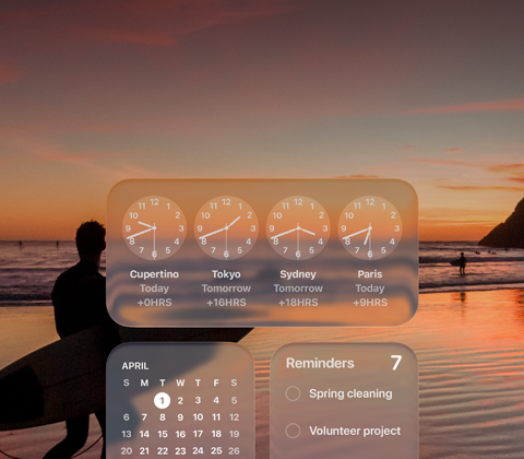 Los widgets Reloj, Calendario, Recordatorios y Clima con diseño Liquid Glass en la pantalla de macOS Tahoe sobre la imagen de un surfista en la playa al atardecer